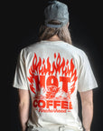 Person wearing a white t-shirt with red graphic and text on the back, standing against a black background.
