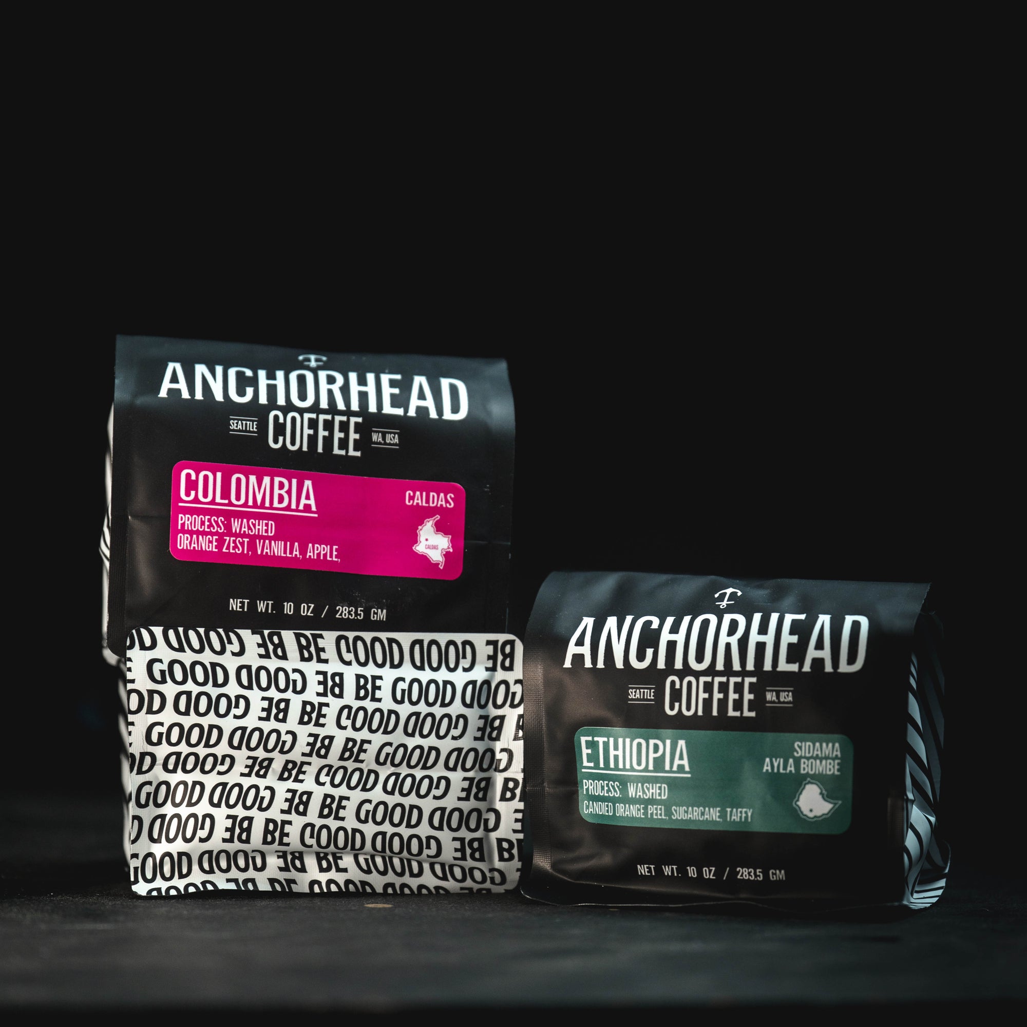 Two Anchorhead Coffee bags, one labeled 'Colombia' and the other 'Ethiopia', on a black background.